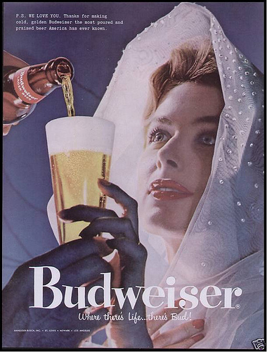 This 1957 Budweiser ad shows a woman in virginal white looking up at her male beer provider. A bit submissive, no?
This 1957 Budweiser ad shows a woman in virginal white looking up at her male beer provider. A bit submissive, no?