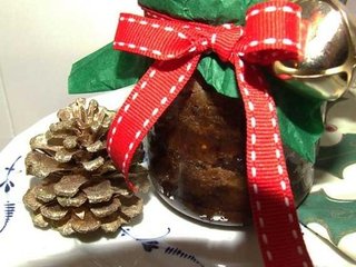 Christmas pudding in jar gift-wrapped with seasonal colours and a little bell. Christmas pudding in jar gift-wrapped with seasonal colours and a little bell.