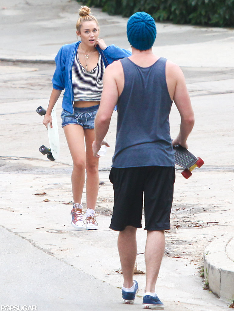 Miley Cyrus wore a bright blue zip-up and Liam Hemsworth wore a tank top and hat for a skateboarding darte around LA. Miley Cyrus wore a bright blue zip-up and Liam Hemsworth wore a tank top and hat for a skateboarding darte around LA.