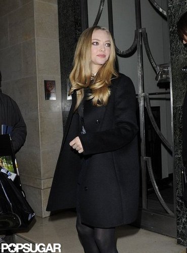 Amanda Seyfried covered her dress with a black coat.
Amanda Seyfried covered her dress with a black coat.