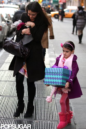 Suri Cruise carried a large present.
Suri Cruise carried a large present.