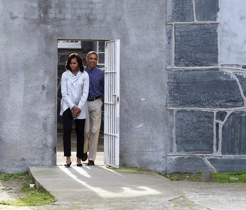 For her visit to Robben Island in South Africa, Michelle kept her look much more subdued in black cropped trousers and a gray cowl-neck jacket.
For her visit to Robben Island in South Africa, Michelle kept her look much more subdued in black cropped trousers and a gray cowl-neck jacket.