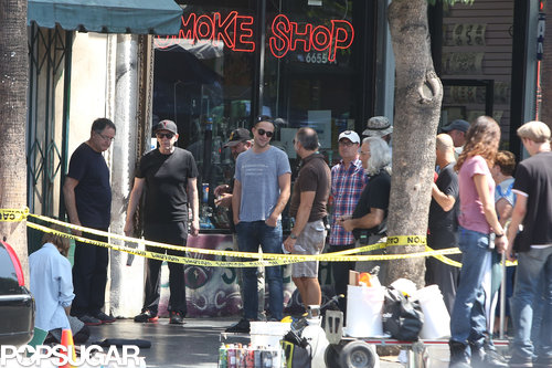 Robert Pattinson wore a gray t-shirt and a backwards hat on set.
Robert Pattinson wore a gray t-shirt and a backwards hat on set.