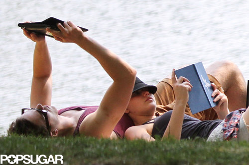 Jennifer Lawrence and Nicholas Hoult both read books on the grass.
Jennifer Lawrence and Nicholas Hoult both read books on the grass.