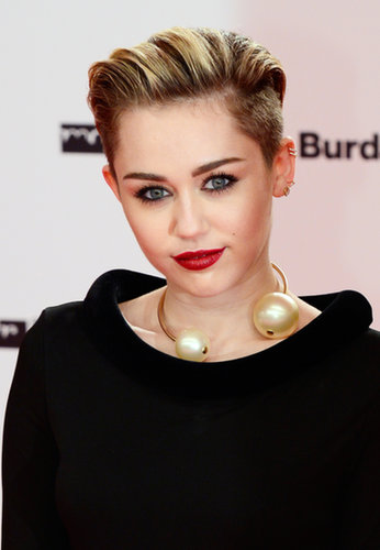 This vampy lipstick and heavy eyeliner combination works perfectly with Miley's slicked-back hairstyle. This appearance was the last time the singer was seen before bleaching her eyebrows.
This vampy lipstick and heavy eyeliner combination works perfectly with Miley's slicked-back hairstyle. This appearance was the last time the singer was seen before bleaching her eyebrows.