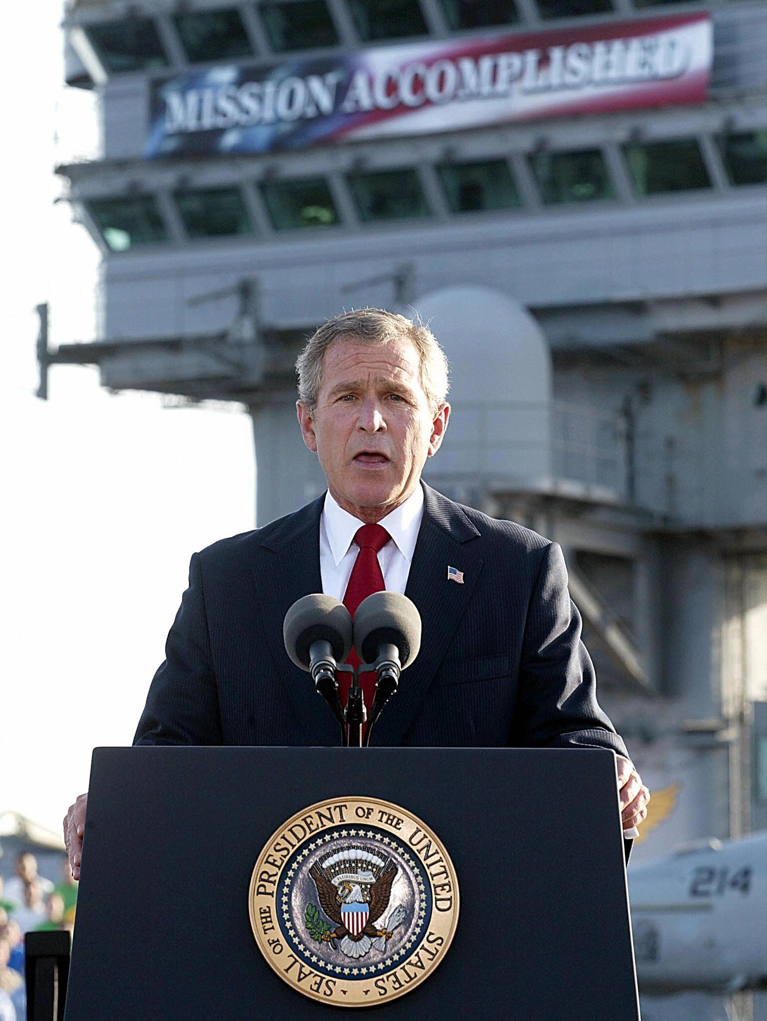 Bush speaks beneath a banner reading "Mission Accomplished" on the USS Abraham Lincoln, May 1, 2003. Bush speaks beneath a banner reading "Mission Accomplished" on the USS Abraham Lincoln, May 1, 2003.