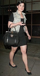 Kelly Osbourne in a Denim Vest Carrying a Top Handle Handbag