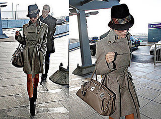 Victoria Beckham Leaves Heathrow Airport in a Trench Coat, Fedora, and Hermes Birkin Bag