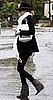 Nicole Richie Walks in the Rain in Gray Wedge Boots, White Scarf, and Black Fedora Hat